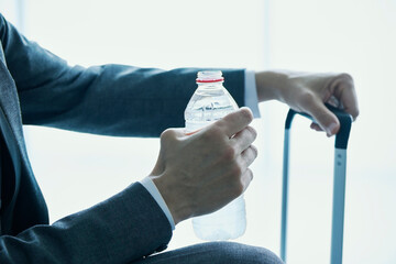 businessman drinking bottled water at the airport