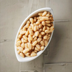 shelled pine nuts in a white bowl