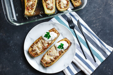 Homemade zucchini stuffed with meat, mushrooms and cheese. Squash boats. Loaded zucchini. Diet menu. Side view, top view.