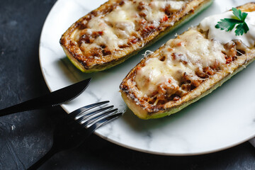 Homemade zucchini stuffed with meat, mushrooms and cheese. Squash boats. Loaded zucchini. Diet menu. Side view, top view.