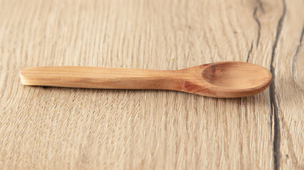 Wooden spoon on a wooden background.