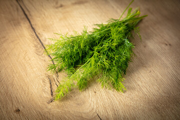 Green dill on a wooden table.