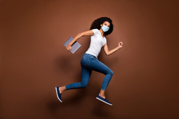 Fototapeta na wymiar Full length body size profile side view of attractive healthy wavy-haired girl wearing gauze safety mask jumping carrying laptop running health care marathon isolated dark brown color background