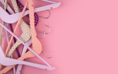 Purple and pink wooden clothes hangers on a pink background copy space.