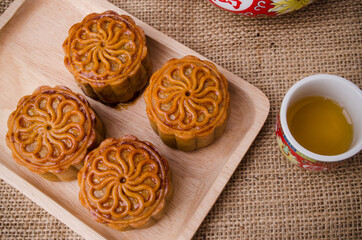Chinese mid autumn festival foods. Traditional mooncakes on table setting with teapot.