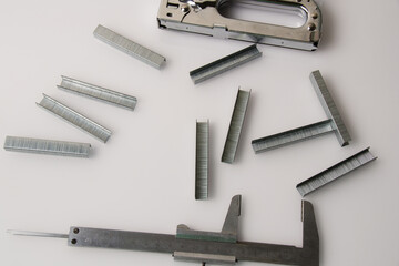 Construction brackets, stapler and ruler on a light background with copy space. The concept of...