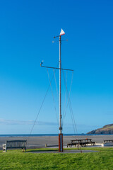 Fototapeta na wymiar Nautical flag pole with weathervane and blue sky background located at Newport Boat Club, Newport, Pembrokeshire. Wales. UK