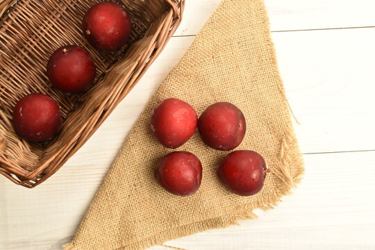 Juicy, tasty, organic red plum, close-up, on a painted wooden table.