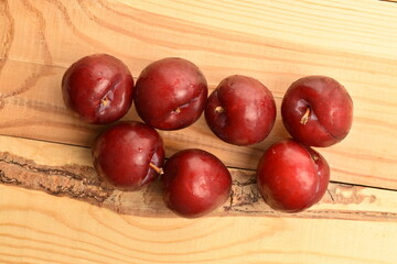 Juicy, tasty, organic red plum, close-up, on a wooden table.