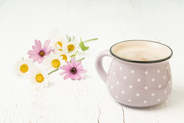 Cup of coffee on a wooden table decorated with flowers