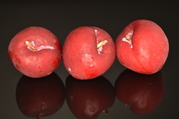 Juicy, tasty, organic red plum, close-up, on a black background.