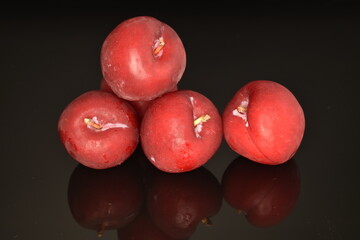 Juicy, tasty, organic red plum, close-up, on a black background.