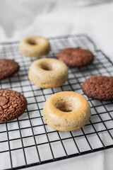 Donuts and whoopie pies on a baking grid.