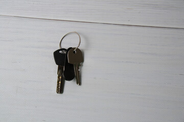 Keys to the apartment or house, intercom key on a light wooden background.