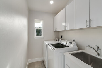 White laundry room features washer and dryer