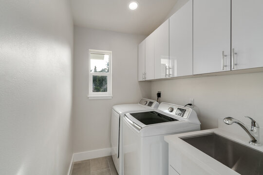 White laundry room features washer and dryer