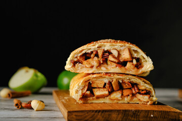  Traditional puff strudel with apple filling Two slices of apple strudel on a dark background. High quality illustration