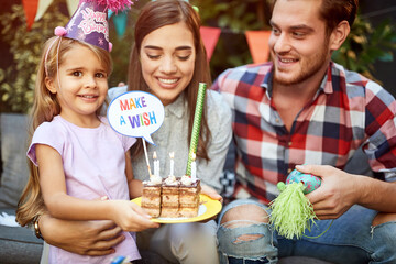 B-day girl holding b-day cake and making a wish