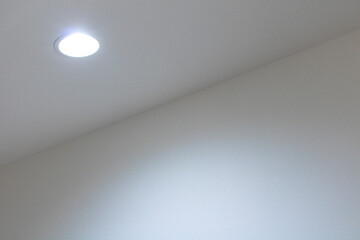 光っている廊下のダウンライトと、光の当たった壁