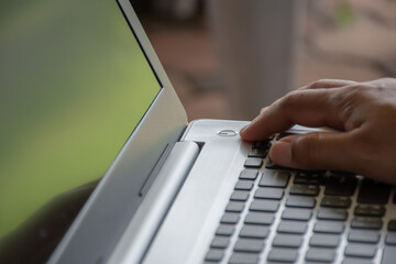 After saving all work Use your finger to press the button to turn off the silver notebook computer,...