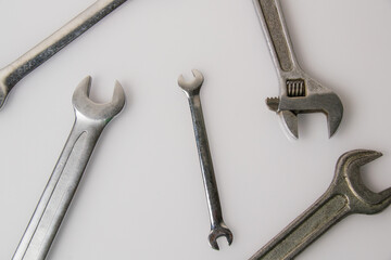 Several different wrenches on a gray glossy surface