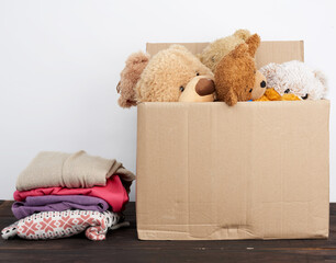 brown cardboard box filled with things and children's toys, concept of moving