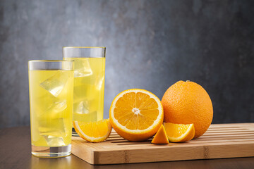 Two glass with orange juice and copy space for text. On gray stone background