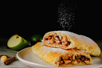  Traditional puff strudel with apple filling Two slices of apple strudel on a dark...