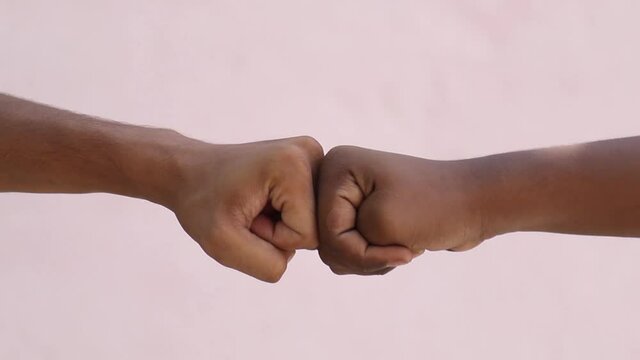 Black African American race male and white Caucasian woman hands giving a fist bump in agreement partnership and cooperation multiracial diversity and immigration concept. Stop racism campaign.