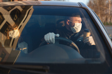 Fototapeta na wymiar Man in the medical mask and rubber gloves for protect himself from bacteria and virus while driving a car. masked man in a car. coronavirus, disease, infection, quarantine, covid-19