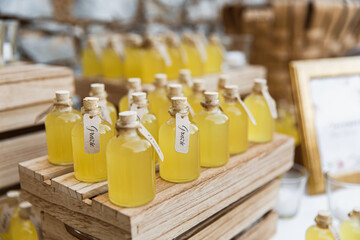 Bottles of limoncello on wooden stands. Closed with corks.