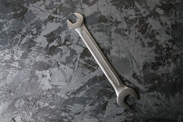 Vintage open end wrench on dark gray background with place for text.