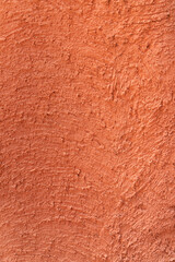 red - orange colour on the abstract random texture curve cement on the wall at afternoon time.