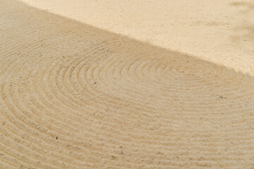 Continuous curve wave pattern art on the sand background.