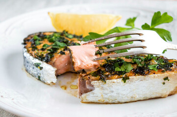 Try a delicious salmon steak. A piece of red fish on a fork