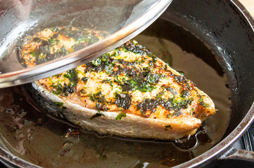Fried red fish in a pan under the lid. Fry salmon in oil