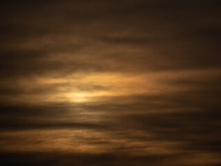 sun peeking through dark clouds