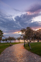 Stone pavement in a public park during sunset with heavy dark clouds. In Athens, Greece