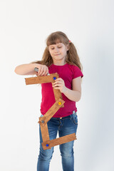 charming girl repairs the number two from a wooden stick