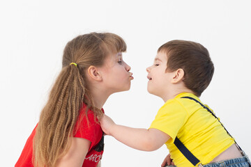 cute boy and girl in bright clothes kissing on a white background