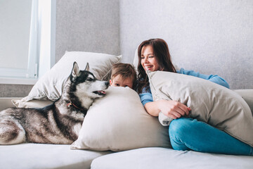 Happy family having fun and spending time with their dog at home