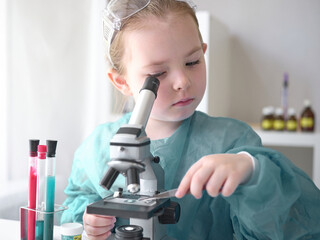 A little girl does scientific work in her home laboratory. The concept is the children of the...