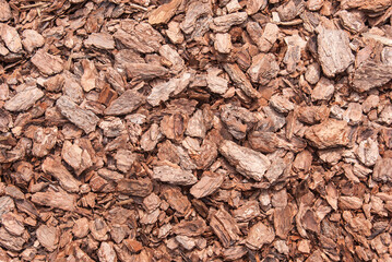 Close-up of red brown mulch made of pine bark. Concept of gardening and landscape decoration.