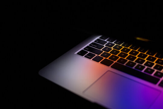 laptop with backlit keyboard at night. copy space. neon