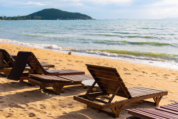 deck chair on the beach on Koh Samui in Thailand, paradise, sunny beach, coconuts and palm trees, sunbathing and swimming in the sea, blue ocean and sky, travel to the resort, relaxation and enjoyment