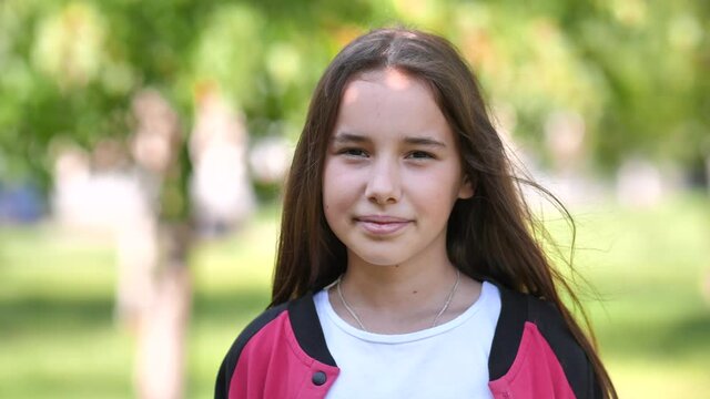 Portrait of a smiling 11 year old girl with long hair.
