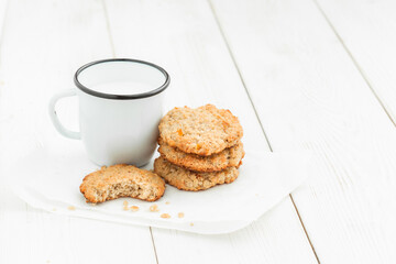 Cookies and a cup of milk on a light wooden table