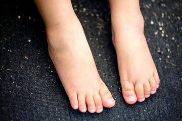 裸足の子供の足と黒バックとコピースペース