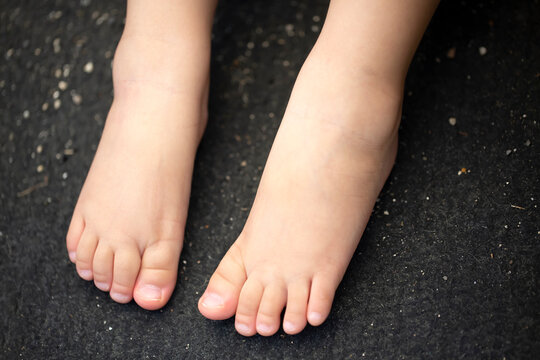 裸足の子供の足と黒バックとコピースペース