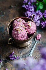 Obraz na płótnie Canvas Homemade berry sorbet ice cream with nuts. Bouquet of lilacs on the table.